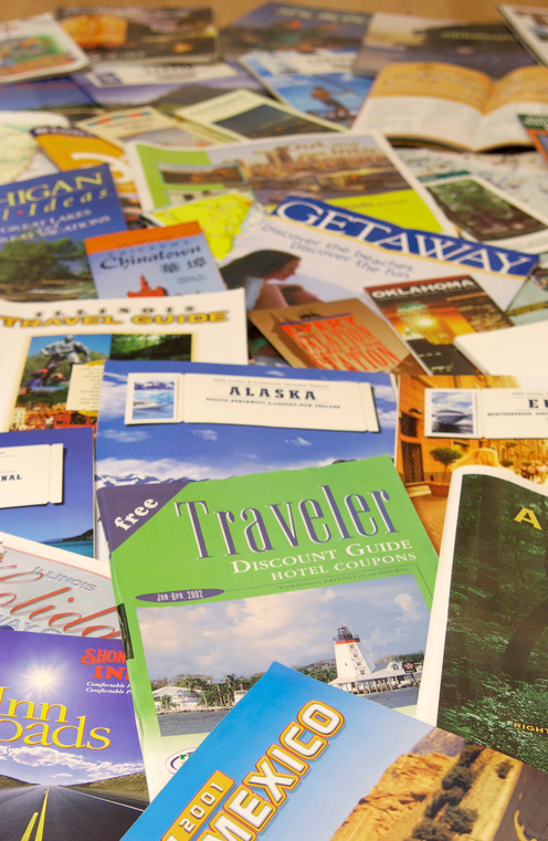 A texture of different, spread out travel brochures